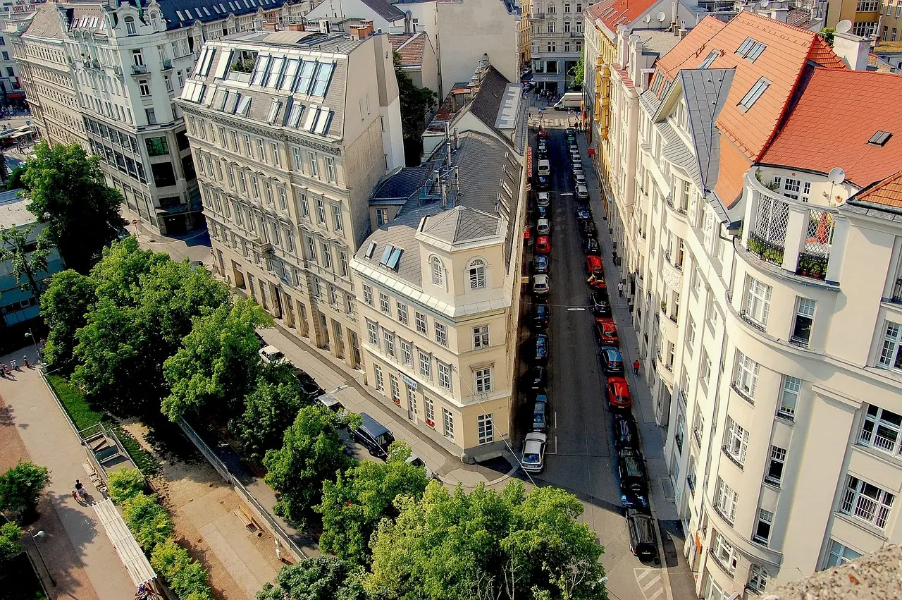 Aerial view of adjoining historic Vienna buildings, a narrow street, and trees