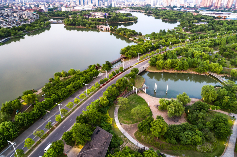 Aerial view of green urban infrastructure with waterways and roads, symbolizing climate-resilient city planning.