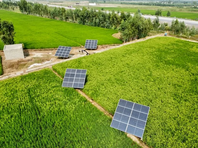 Solar panels installed across green agricultural fields, representing off-grid renewable energy solutions for remote communities.